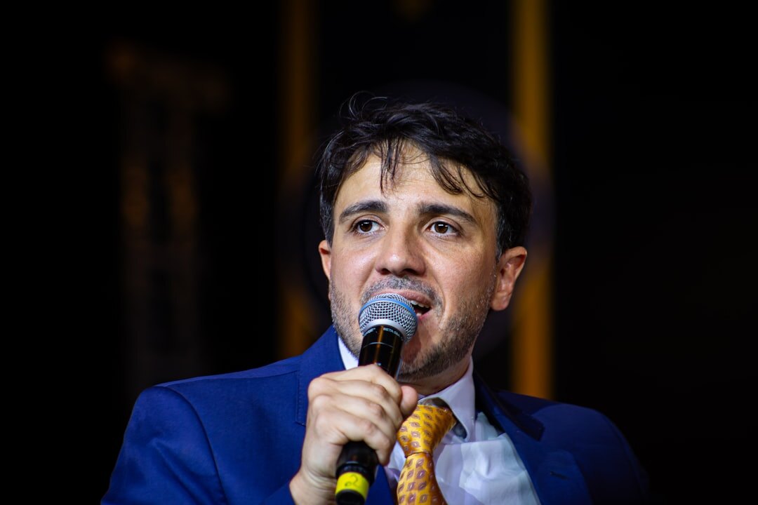 TV presenter speaking in front of a camera under studio lights
