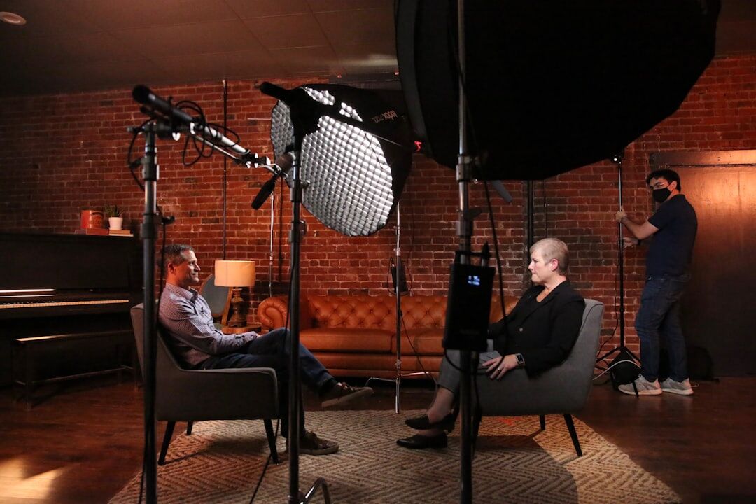 Diverse group of students filming in a television studio with professional camera and lighting